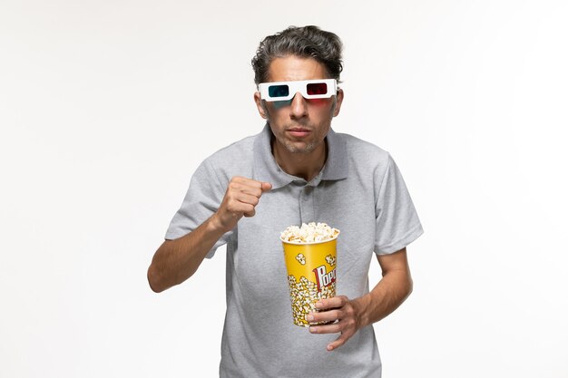 Front view young male eating popcorn in d sunglasses on white surface