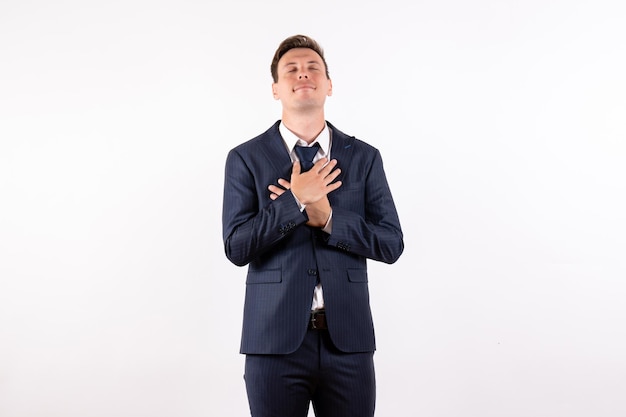 Front view young male in elegant classic suit posing with delighted expression on white background