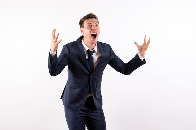 Front view young male in elegant classic suit screaming emotionally on white background