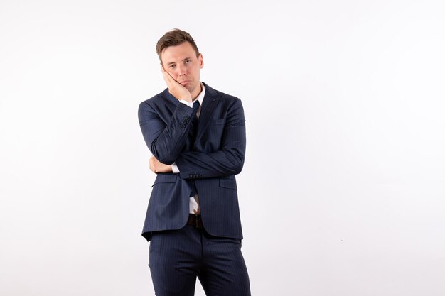 Front view young male in elegant classic suit and waiting pose on white background