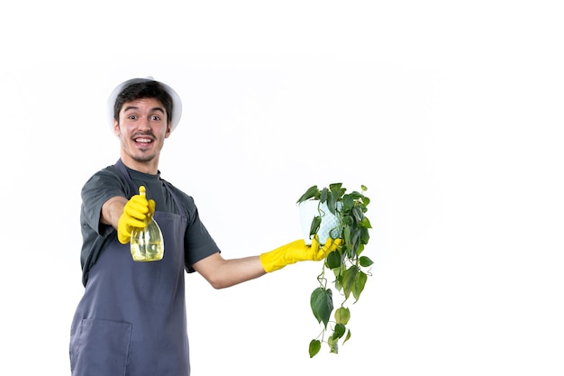 Front view young male gardener spraying plant in pot on the white background flower work tree grass color ground job garden