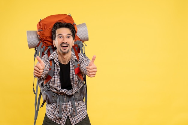 Front view young male going in hiking with backpack delighted on yellow background trip campus height mountain human color tourist