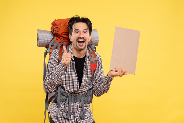 Front view young male going in hiking with backpack on the yellow background color air trip nature campus forest emotion company