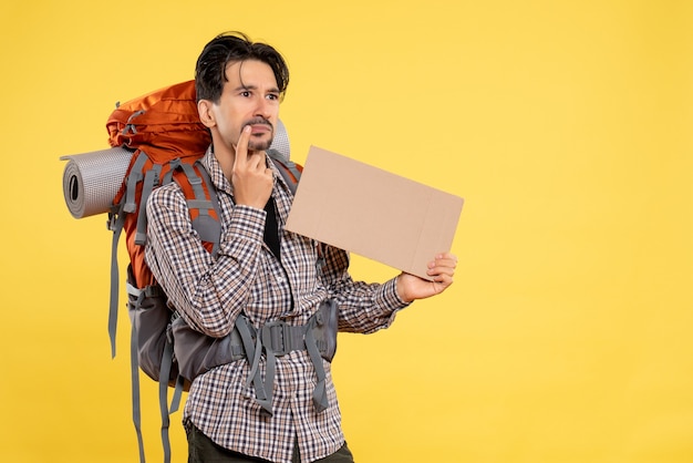 Front view young male going in hiking with backpack on yellow background color emotions air trip nature campus