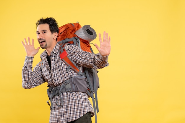 Front view young male going in hiking with backpack on a yellow background mountain campus color human height tourist