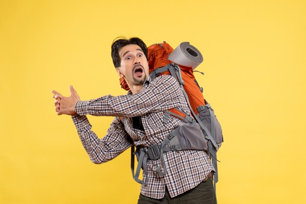 Front view young male going in hiking with backpack on yellow 