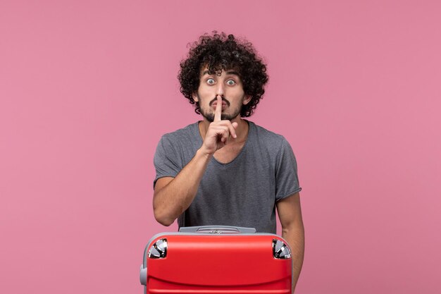 Front view young male going in vacation with his red bag on pink space