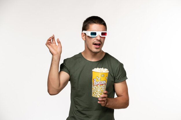 Front view young male in green t-shirt holding popcorn in d sunglasses on the white desk film lonely cinema male movie