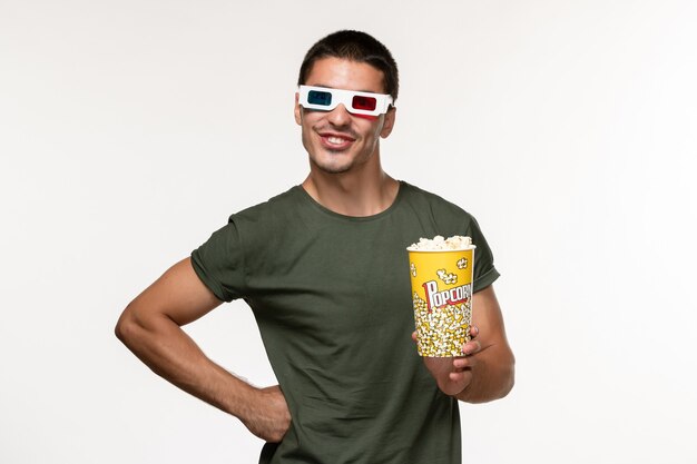 Front view young male in green t-shirt holding popcorn package in d sunglasses on white desk film lonely cinema male movies