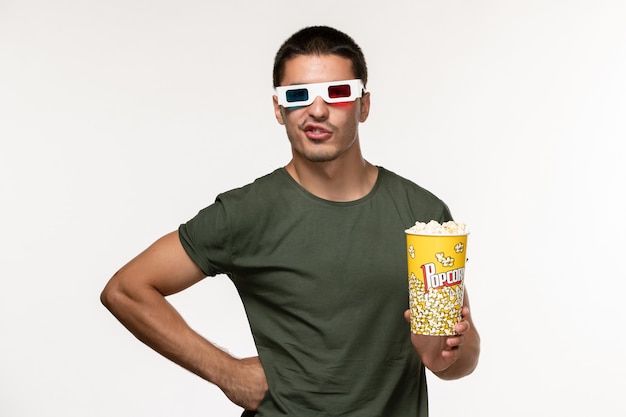 Front view young male in green t-shirt holding popcorn package in d sunglasses on the white wall film lonely cinema male movies