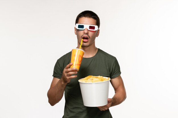 Front view young male in green t-shirt holding potato cips soda in d sunglasses on white desk film male lonely movie cinema