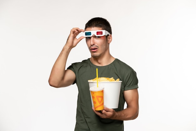 흰 벽 필름 남성 외로운 영화에 D 선글라스에 감자 CPS와 소다를 들고 녹색 티셔츠에 전면보기 젊은 남성