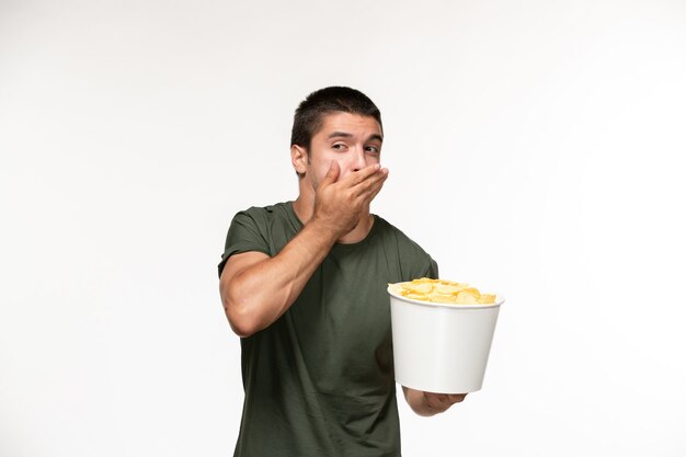 Front view young male in green t-shirt holding potato cips on white wall film movie cinema person