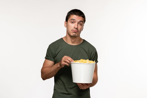 Front view young male in green t-shirt with potato cips watching movie on white wall film person male lonely movies cinema