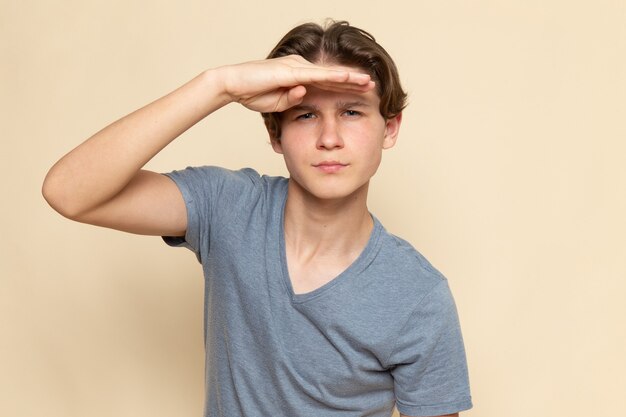 A front view young male in grey t-shirt looking into the distance