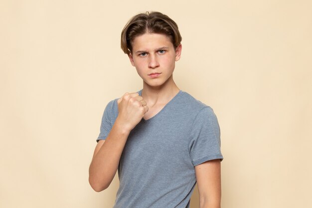 A front view young male in grey t-shirt posing with aggressive body language