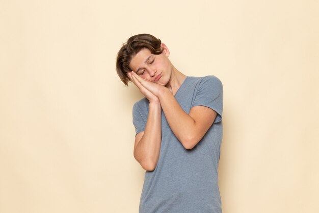 灰色のtシャツで眠っている表情でポーズの正面の若い男性