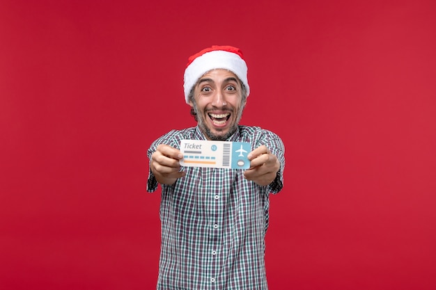 Front view young male happily holding ticket on red background