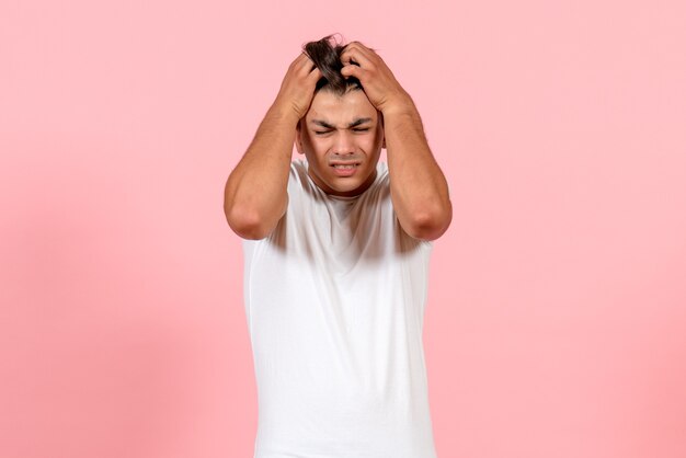 Front view young male having headache on pink background male color model emotion