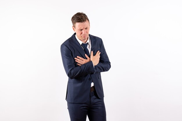 Front view young male having health problems in classic strict suit on white background fashion model male business emotions