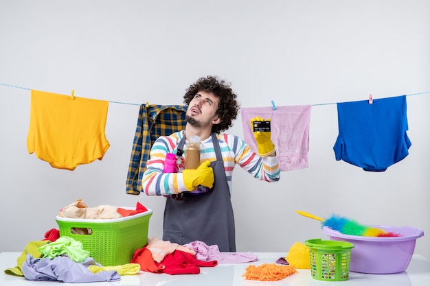 Free photo front view young male holding bank card and shampoos on white wall