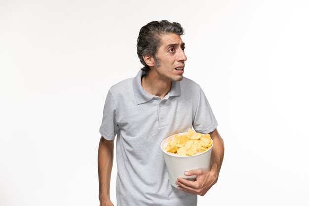 Front view young male holding basket with potato chips on light white surface