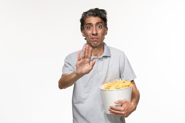 Front view young male holding basket with potato chips on a white surface