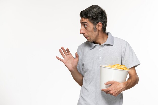 Front view young male holding basket with potato chips on a white surface