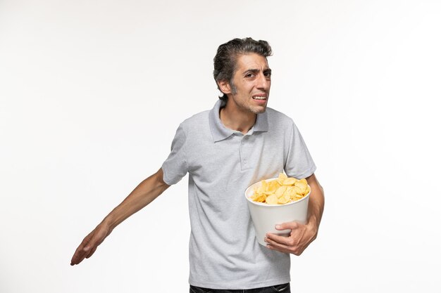 Free photo front view young male holding basket with potato chips on white surface