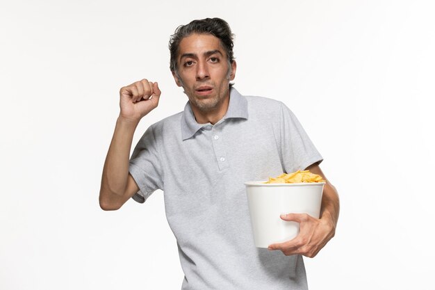 Front view young male holding basket with potato chips on white surface