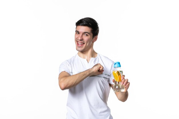 Front view young male holding bottle of lemonade on white