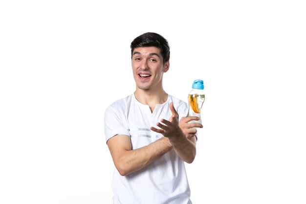 Front view young male holding bottle of lemonade on white