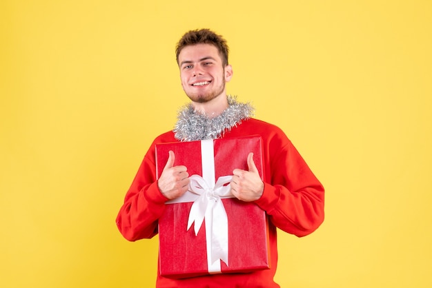 Front view young male holding christmas present