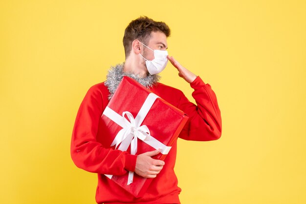 Front view young male holding christmas present