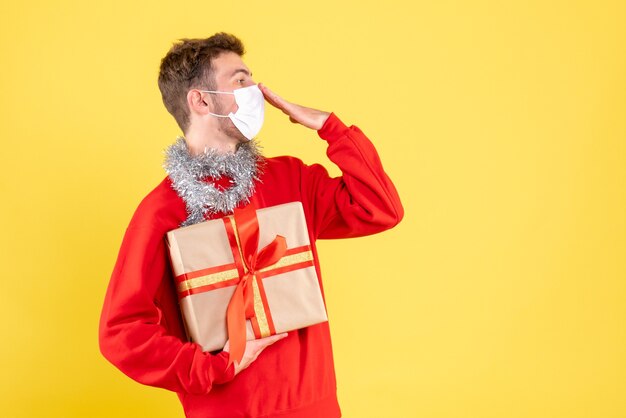 Front view young male holding christmas present