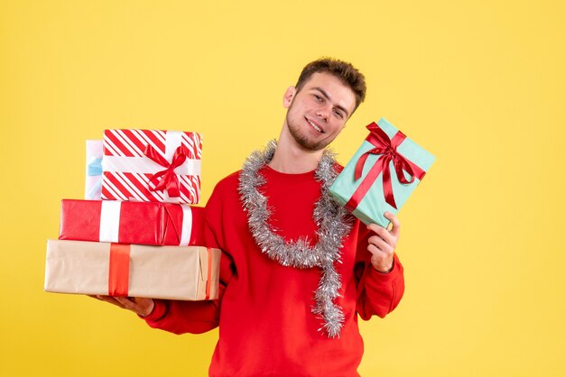 クリスマスプレゼントを保持している正面図若い男性