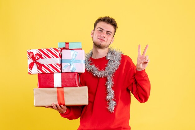 Front view young male holding christmas presents