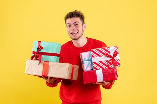 Front view young male holding christmas presents