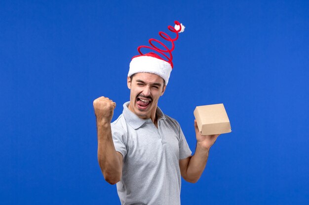 Front view young male holding food package on blue wall food male service job emotion