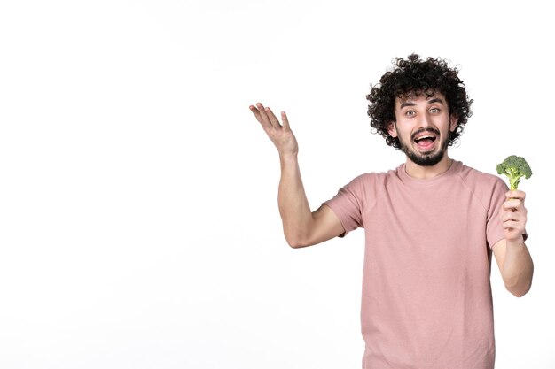 Front view young male holding little green broccoli on white background salad body horizontal weight human vegetables diet health