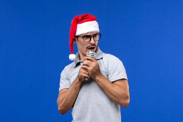 Front view young male holding mic on blue wall new year singers music male