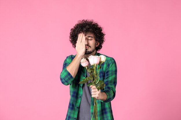 Front view young male holding pink roses on pink color