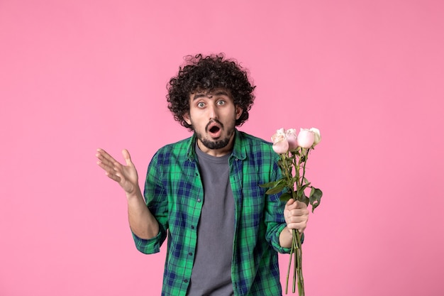 Front view young male holding pink roses on pink color