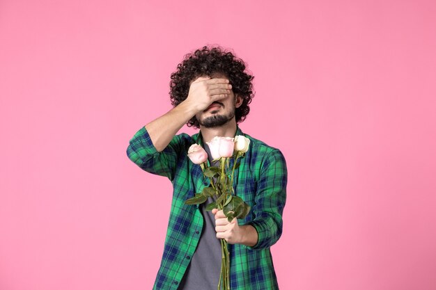 Front view young male holding pink roses on pink color