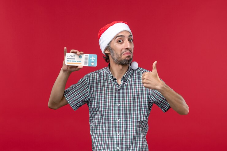 Free Photo front view young male holding plane ticket on red background