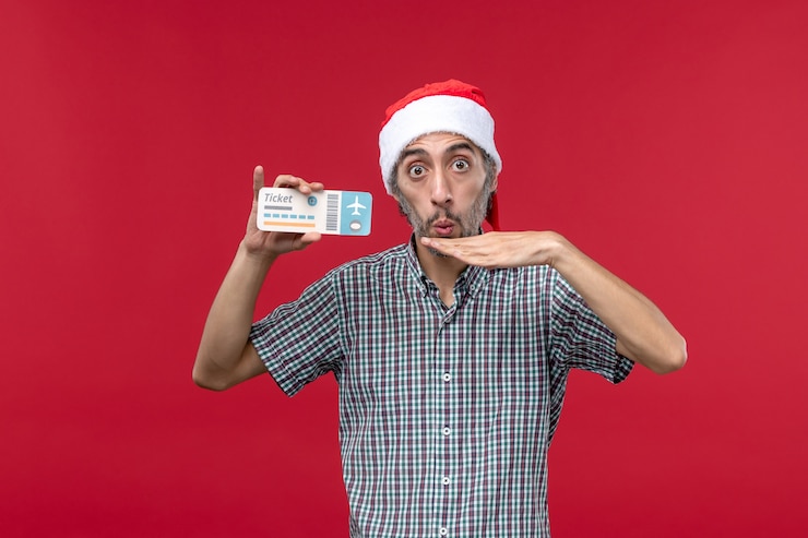 Free Photo front view young male holding plane ticket on red background