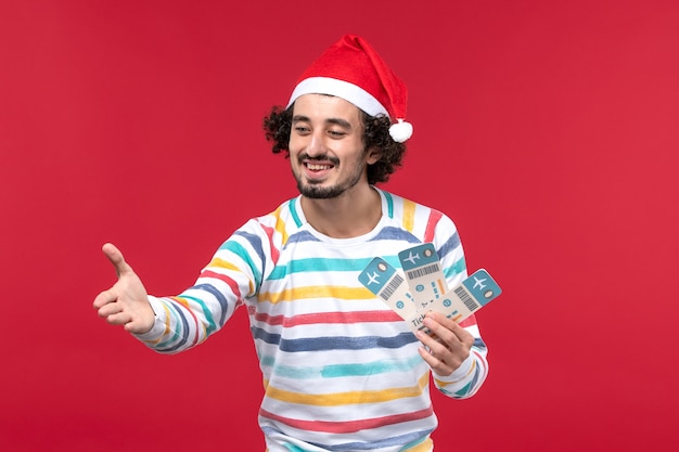 Front view young male holding plane tickets on red desk red holiday new year plane