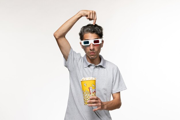 Front view young male holding popcorn in d sunglasses on a light-white surface