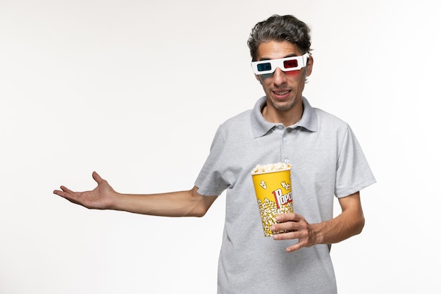 Front view young male holding popcorn in d sunglasses on a white surface