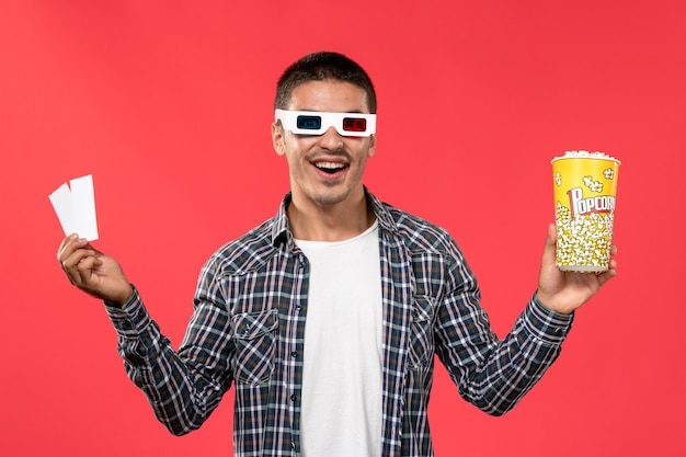 밝은 붉은 벽 남성 영화관 영화 필름에 -d 선글라스에 팝콘 티켓을 들고 전면보기 젊은 남성